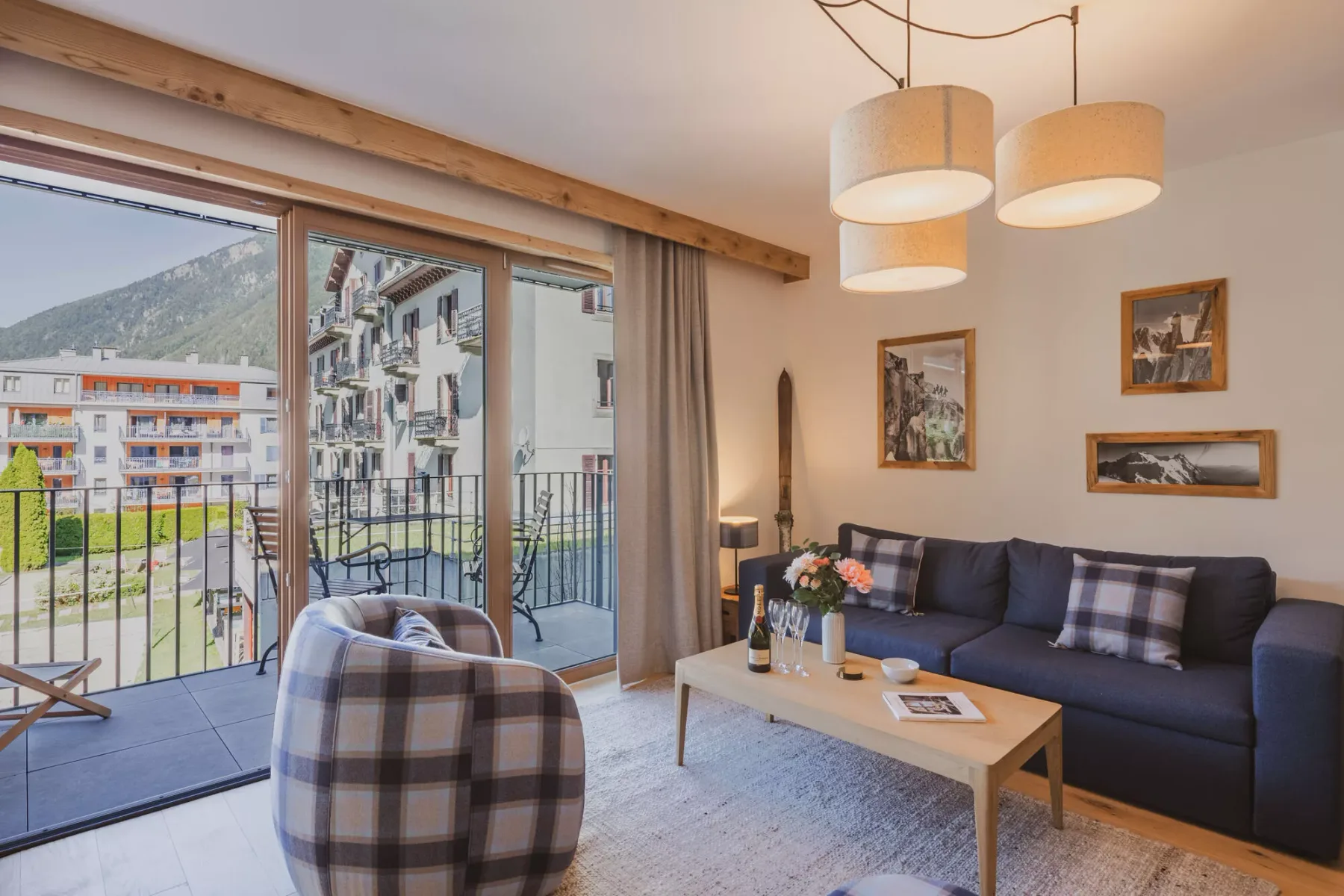 A living room opens onto a balcony, with seating and a coffee table.