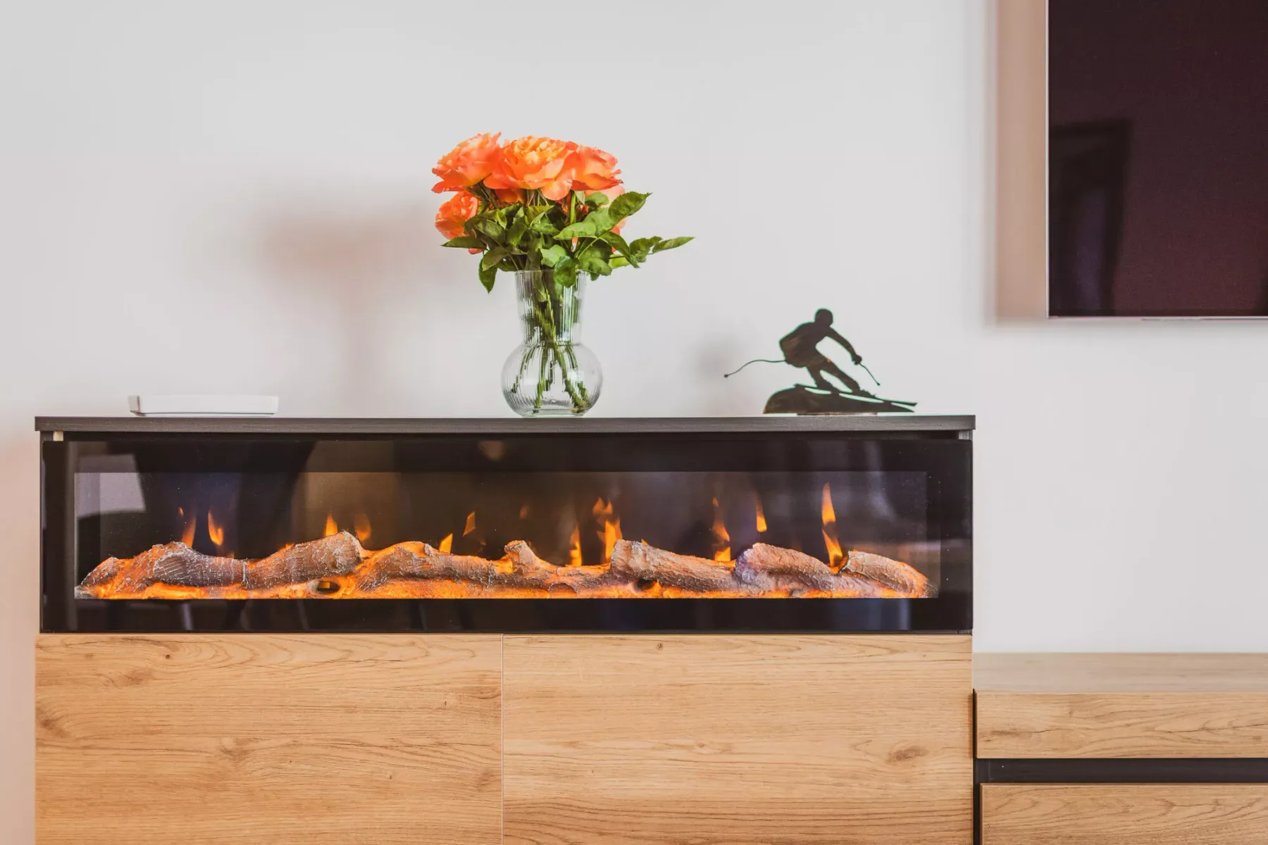 Una chimenea de sala moderna está integrada en un mueble de madera clara.