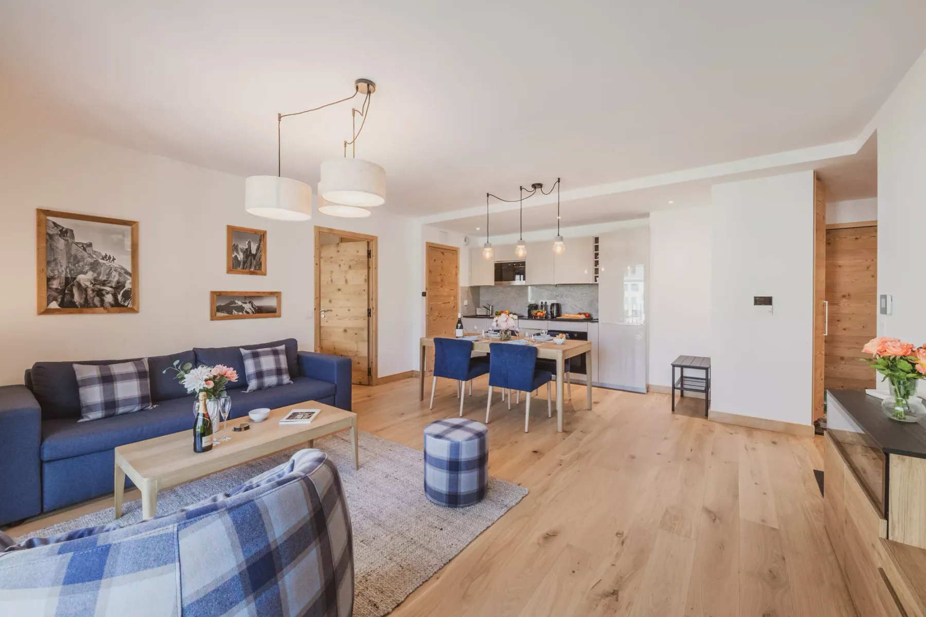 An open-plan living room and kitchen with seating and a dining table.