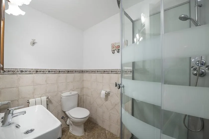 Un baño con lavabo, inodoro y ducha de vidrio.