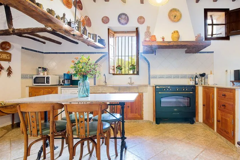Una cocina luminosa con una mesa de comedor y armarios de madera.