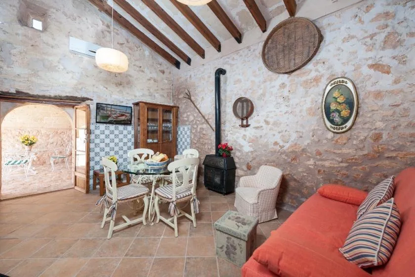 Una sala rústica con mesa de comedor, asientos y una estufa negra.