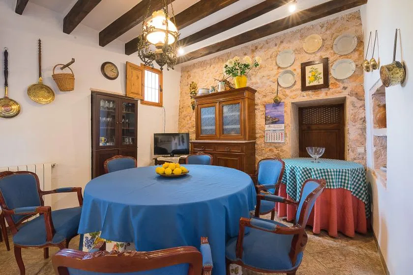 Un comedor rústico con manteles azules y vigas de madera a la vista.