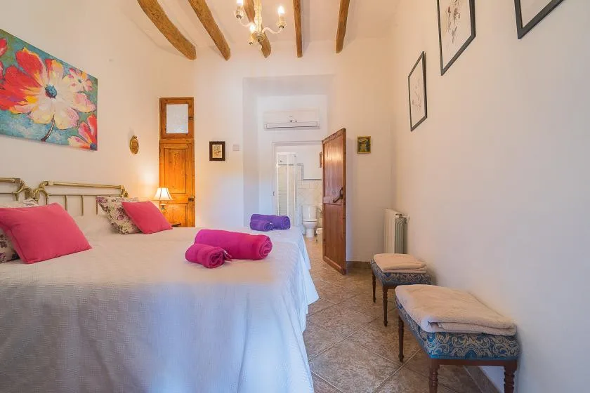 Un dormitorio con una cama grande y una puerta abierta al baño.