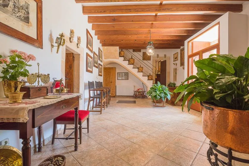 Una estancia luminosa cuenta con vigas de madera expuestas y plantas.