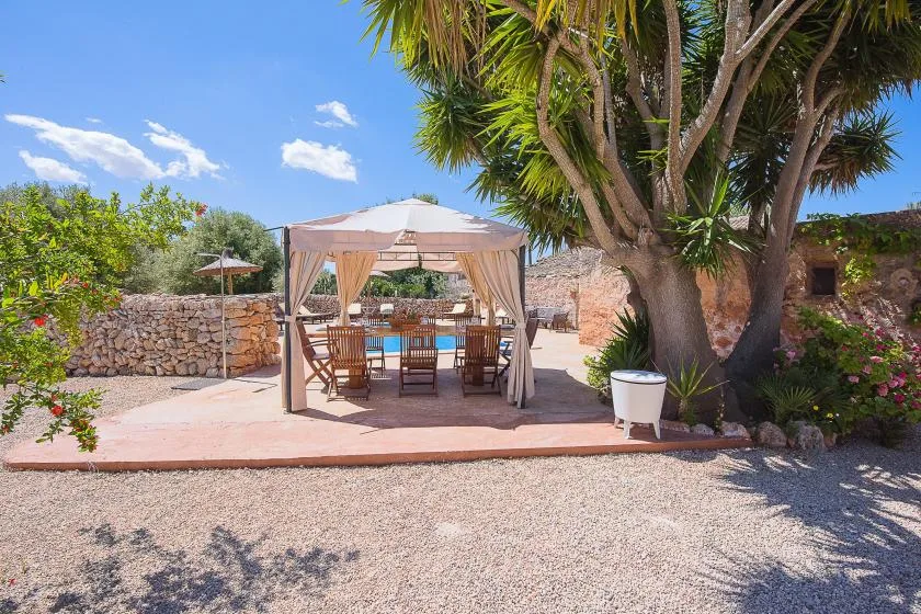 Una zona de comedor al aire libre con una mesa bajo una cubierta de tela.