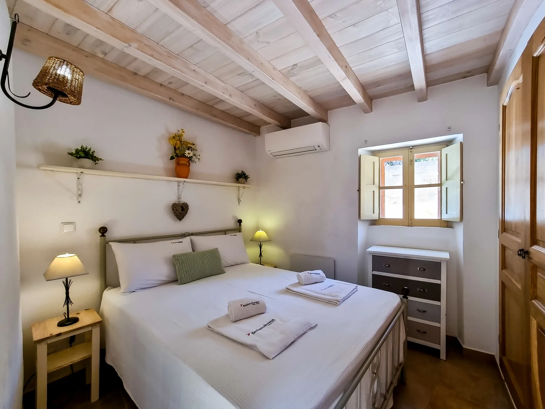 A bright bedroom with a neatly made bed and a window.