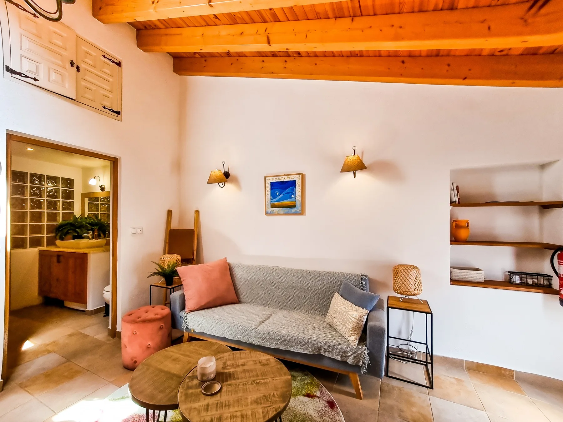 A living room with a sofa, wall lights, and built-in shelves.