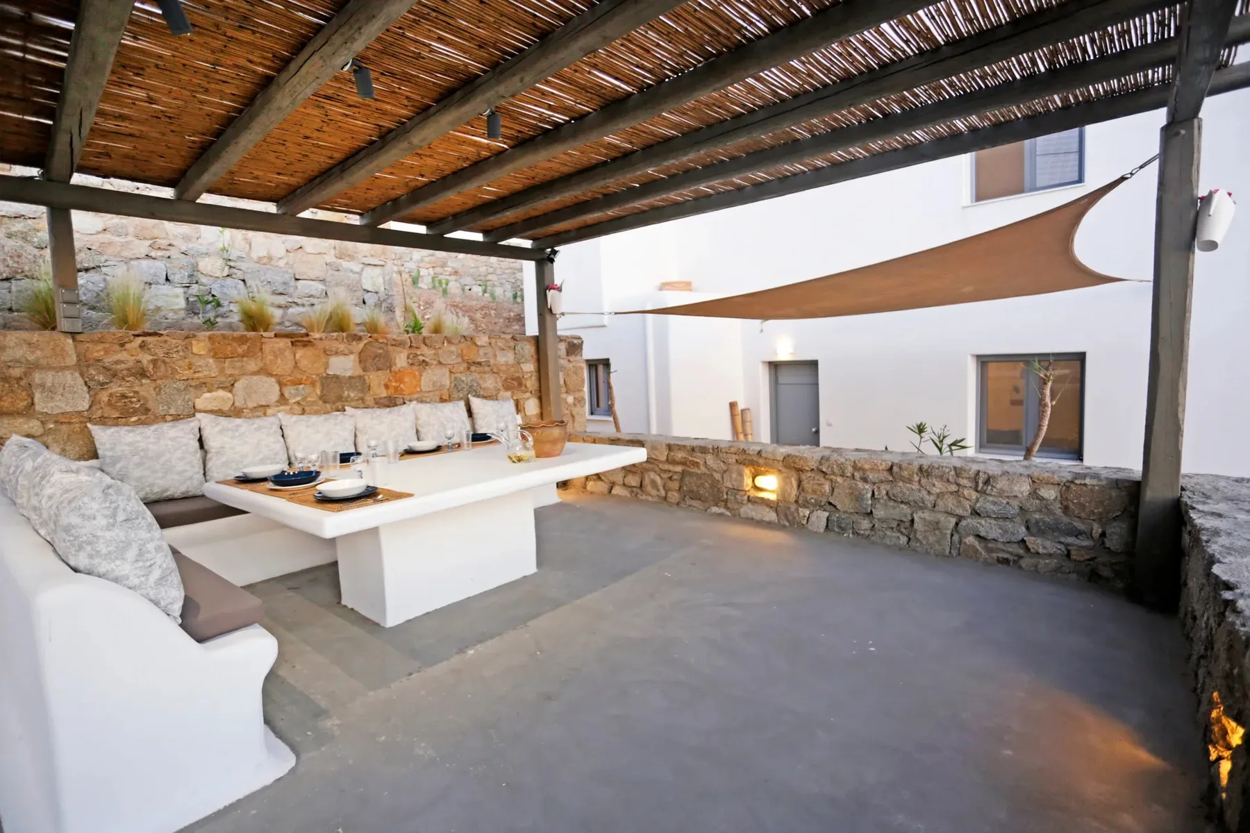 Covered outdoor dining area with built-in seating and a table.