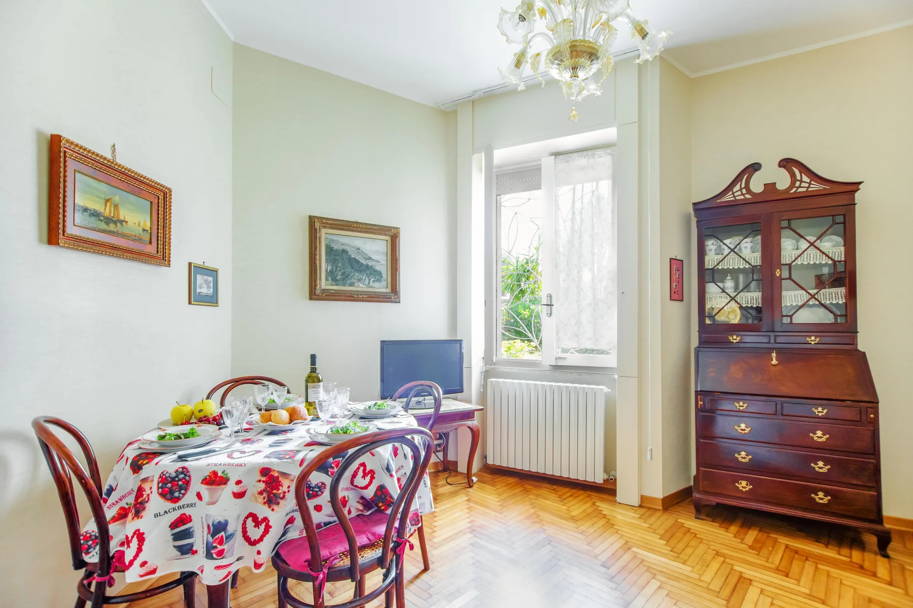 A bright dining room with a set table beside a tall window.