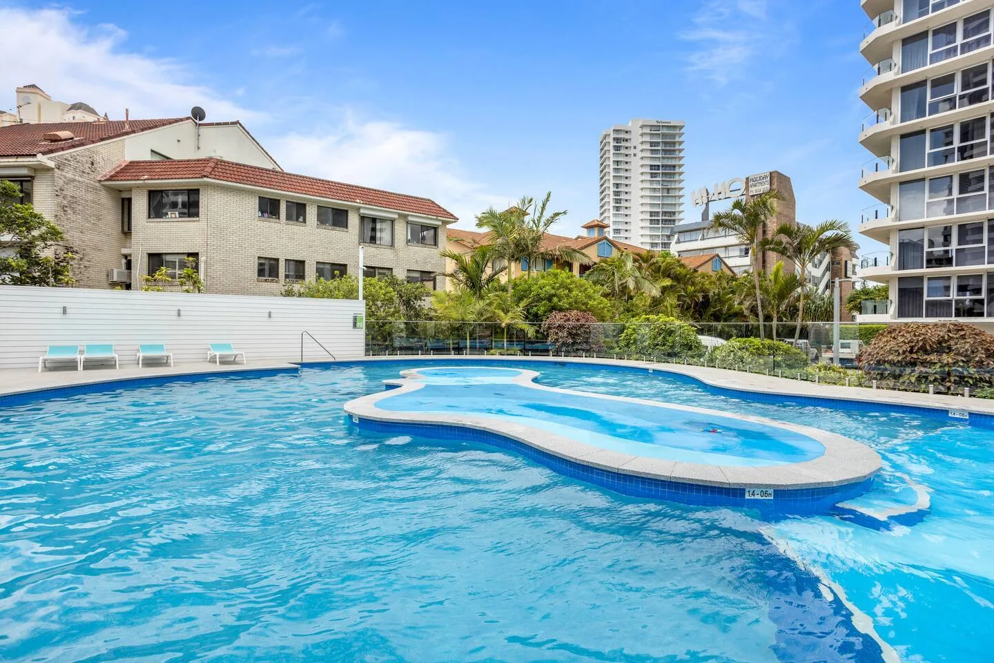 Una piscina al aire libre con una estructura curva elevada en el agua.