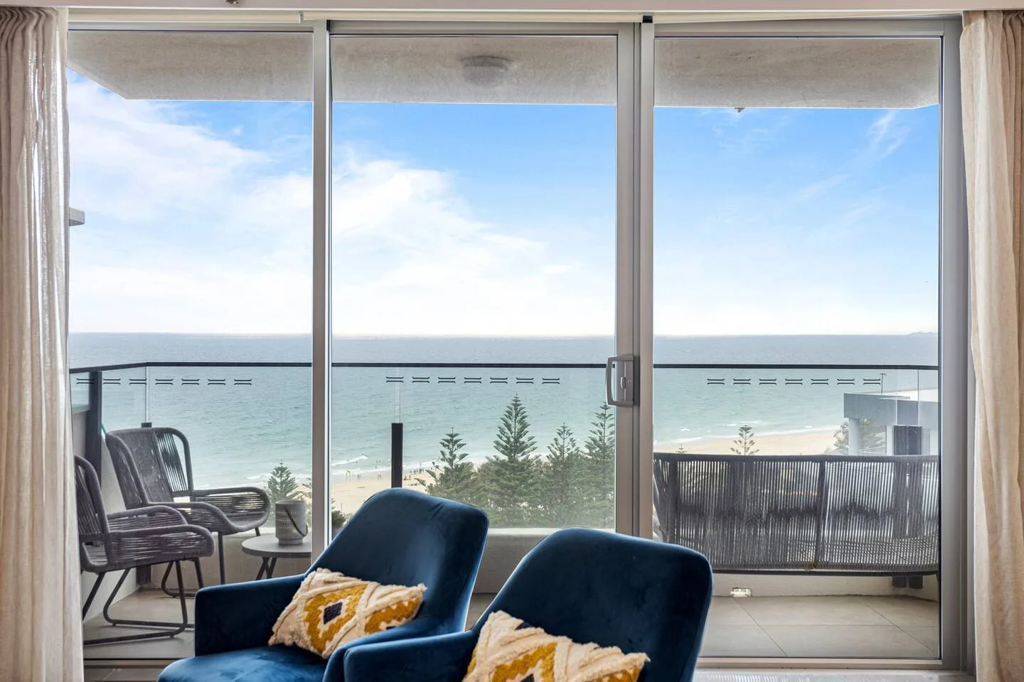 Una luminosa sala de estar da a un balcón con vistas al mar.