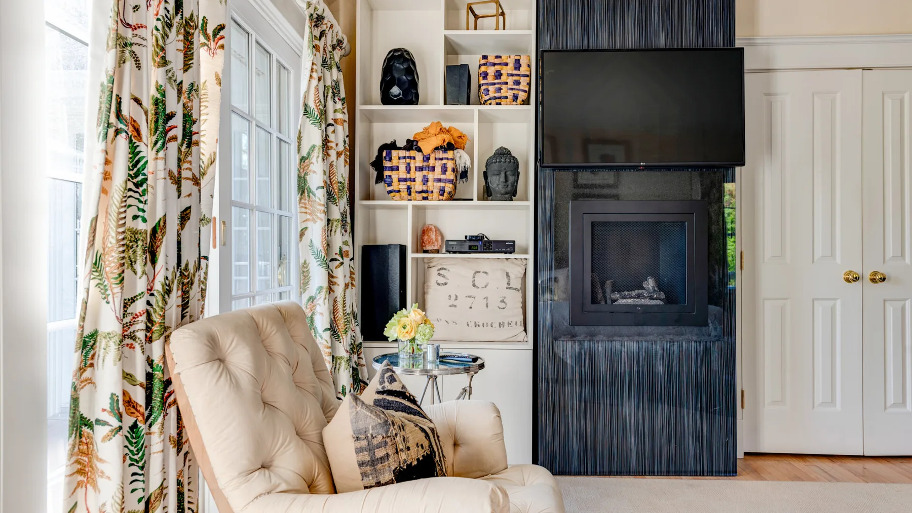 Una sala de estar con asientos acolchados junto a una chimenea y un televisor.
