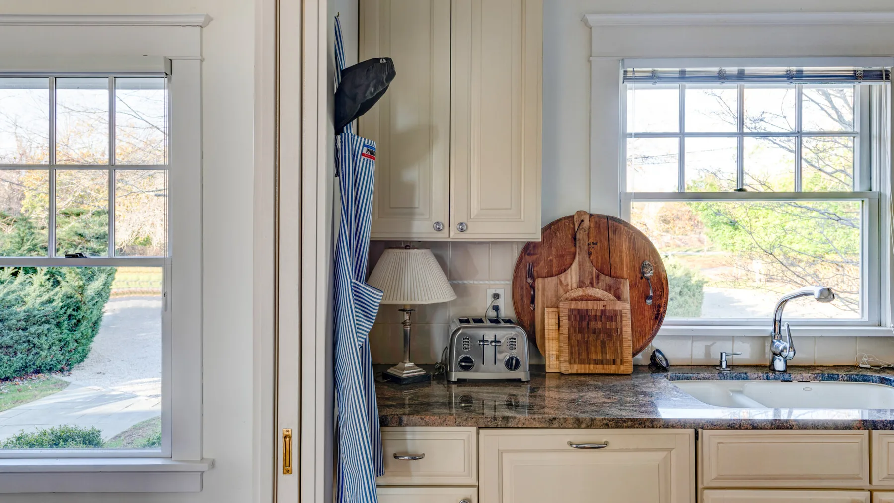 Una cocina luminosa con fregadero y encimera bajo una ventana.