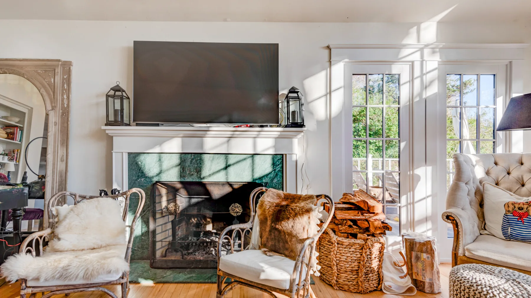 Una sala luminosa con chimenea, televisor y asientos.