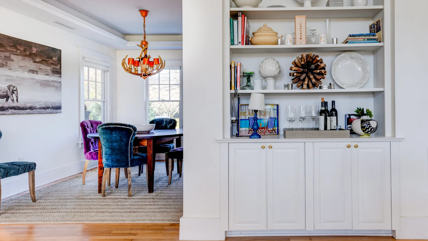 Comedor con asientos tapizados junto a un mueble empotrado con estantes.