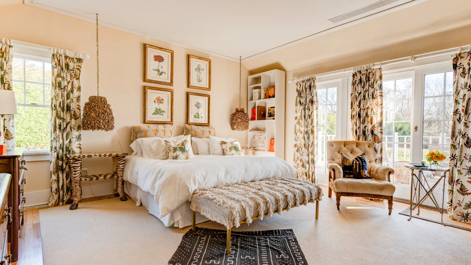 Un dormitorio luminoso con una cama grande y ventanas que dan a un jardín.