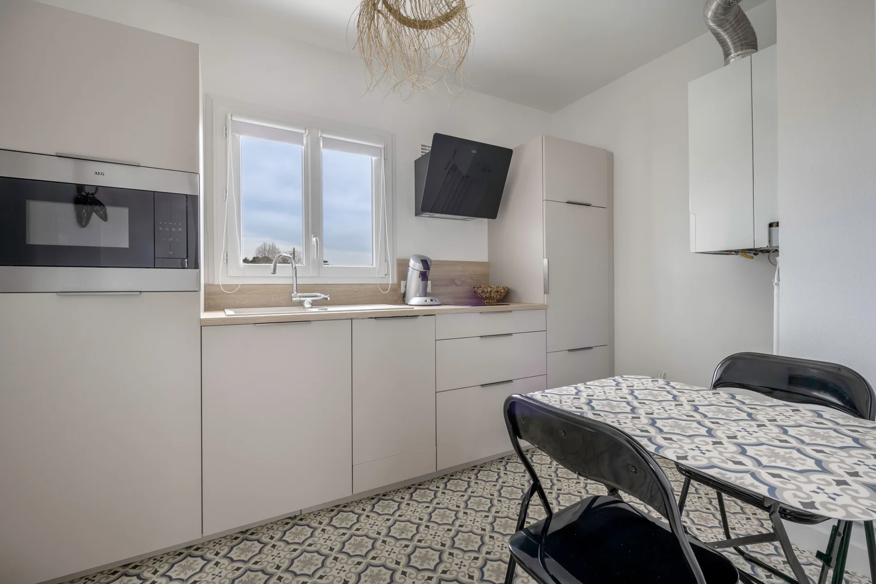 Una cocina luminosa con ventana, encimera y mesa de comedor.