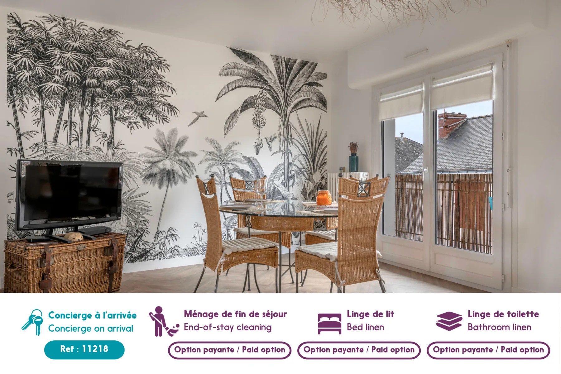Un comedor con asientos de mimbre está junto a ventanas y murales tropicales.