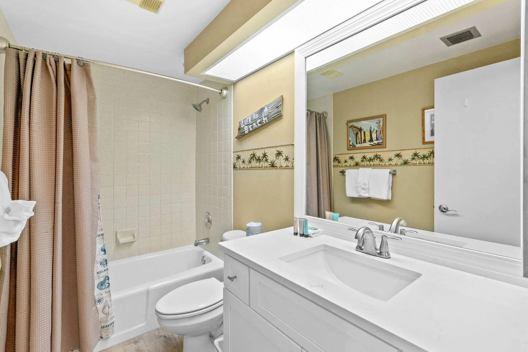 Un baño con bañera, inodoro y un amplio tocador.