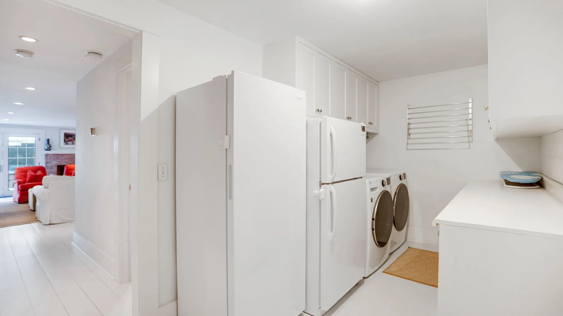 A bright laundry area with a washer and dryer beside a refrigerator.