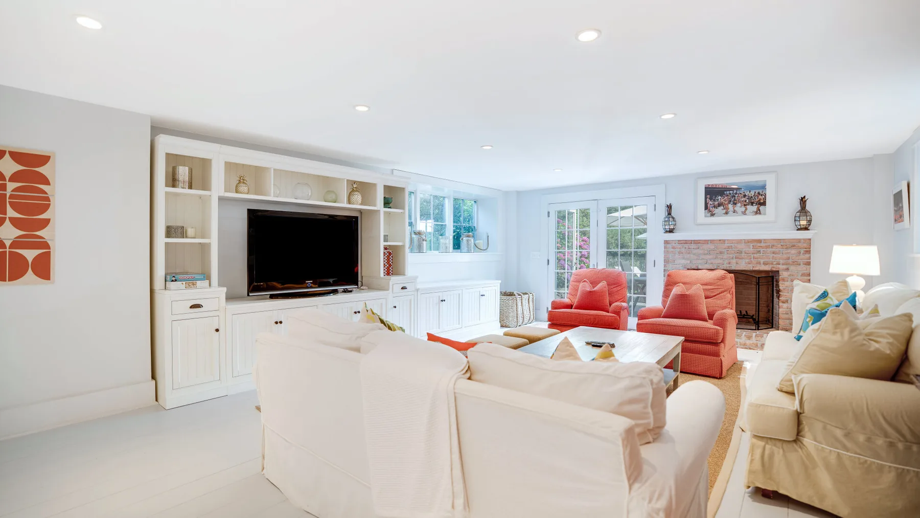 A bright living room with built-in shelving, seating, and a fireplace.