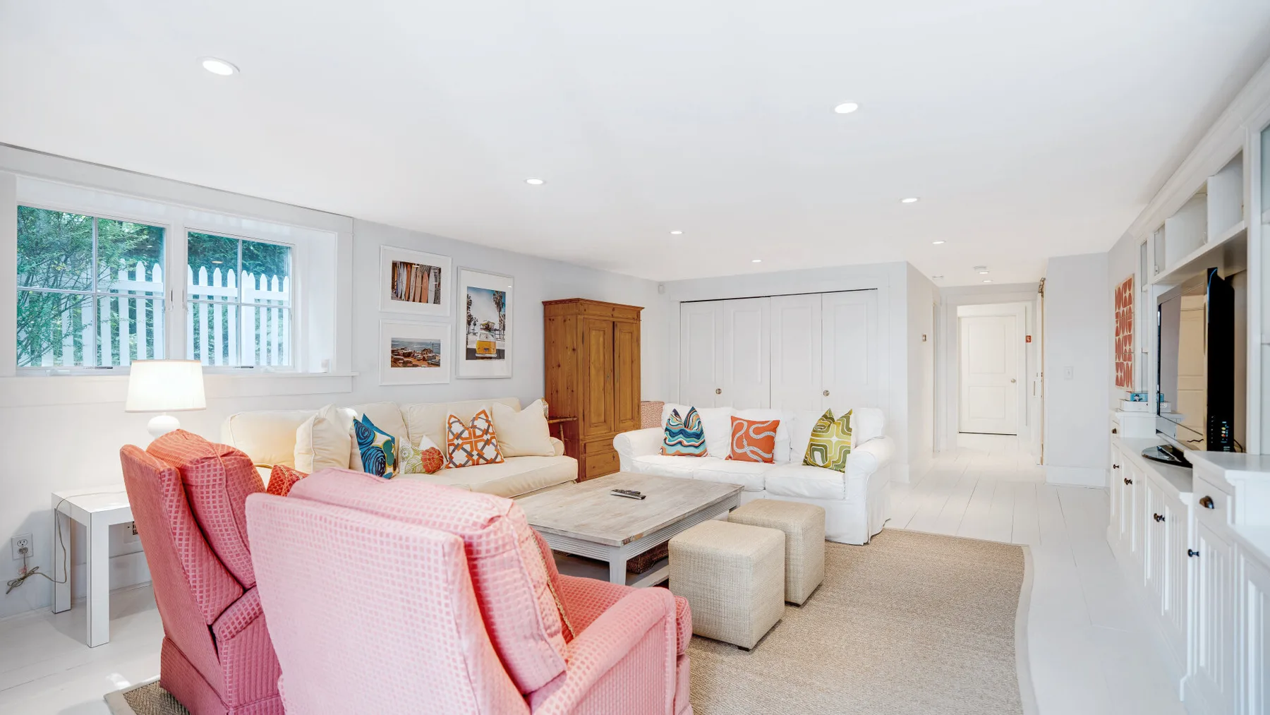 A bright living room with seating around a coffee table and built-in cabinetry.