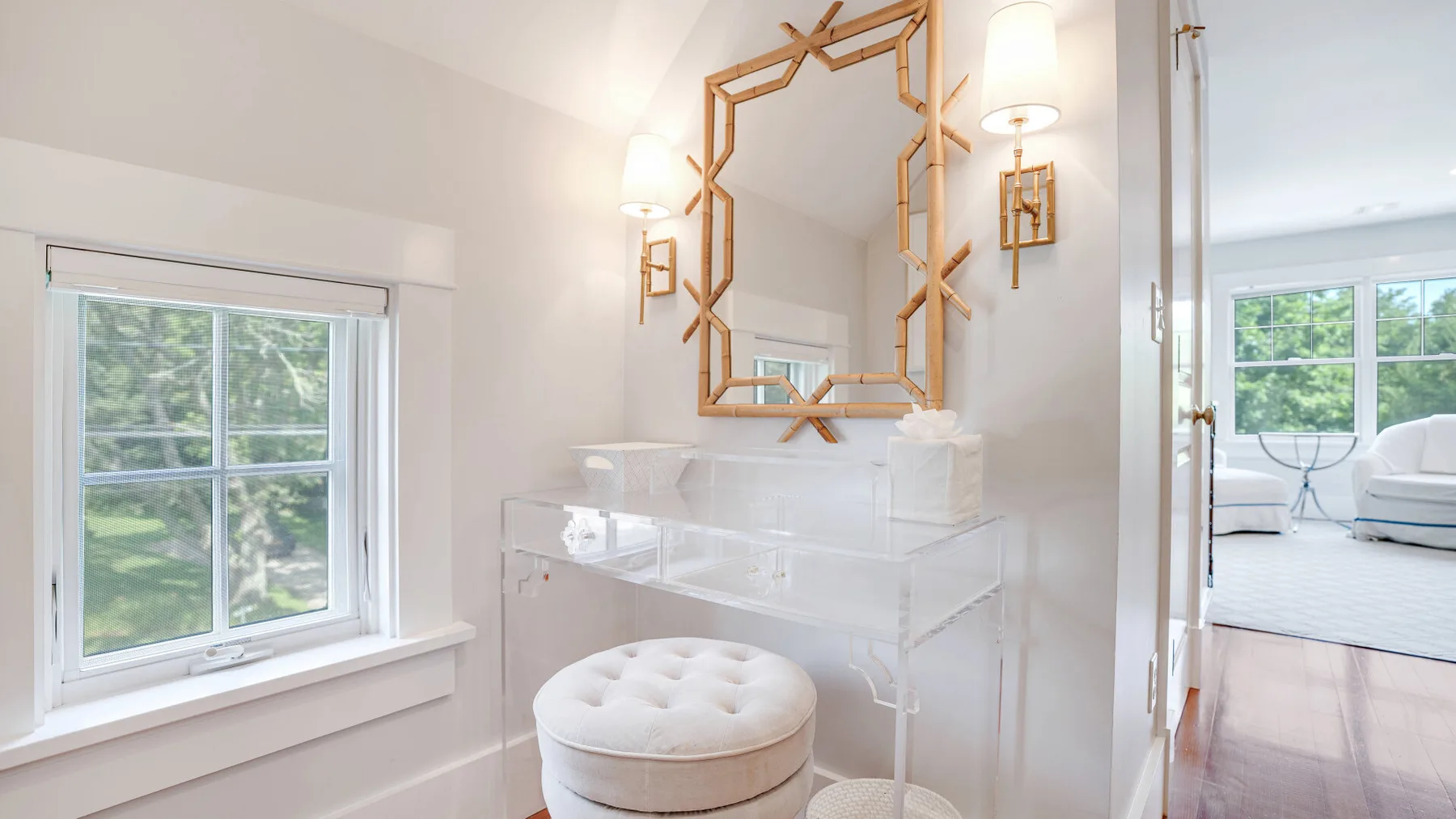 A bright bathroom vanity sits beside a window, with a large decorative mirror above it.