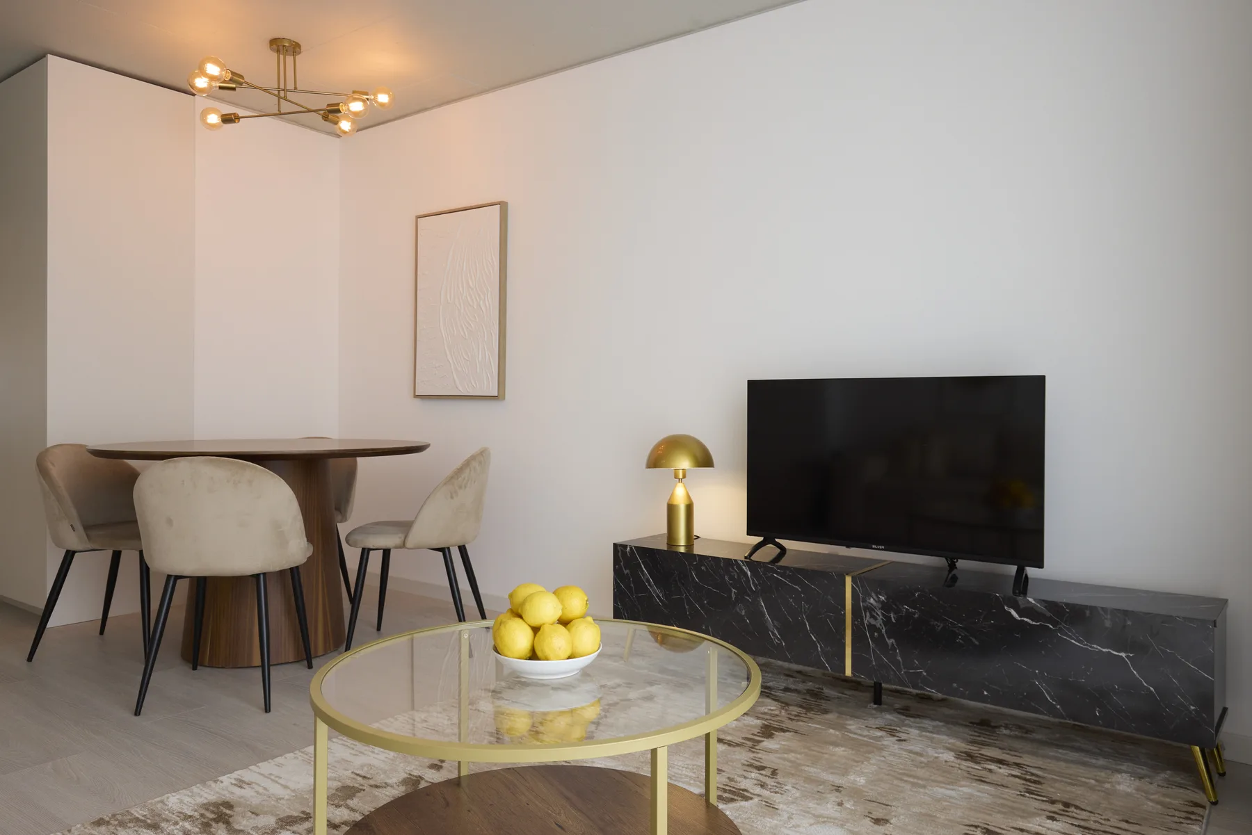 Living room with a television, seating, and a dining table.