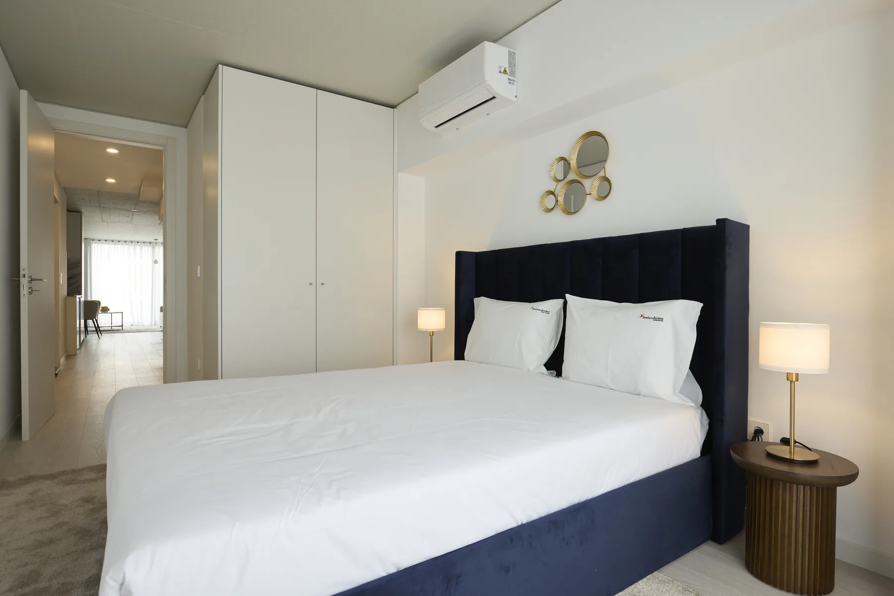 A bedroom with a neatly made bed and bedside lamps.
