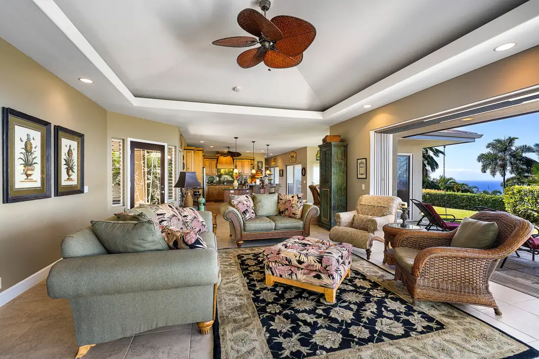 A living room with seating, a patterned rug, and open doors to a patio.