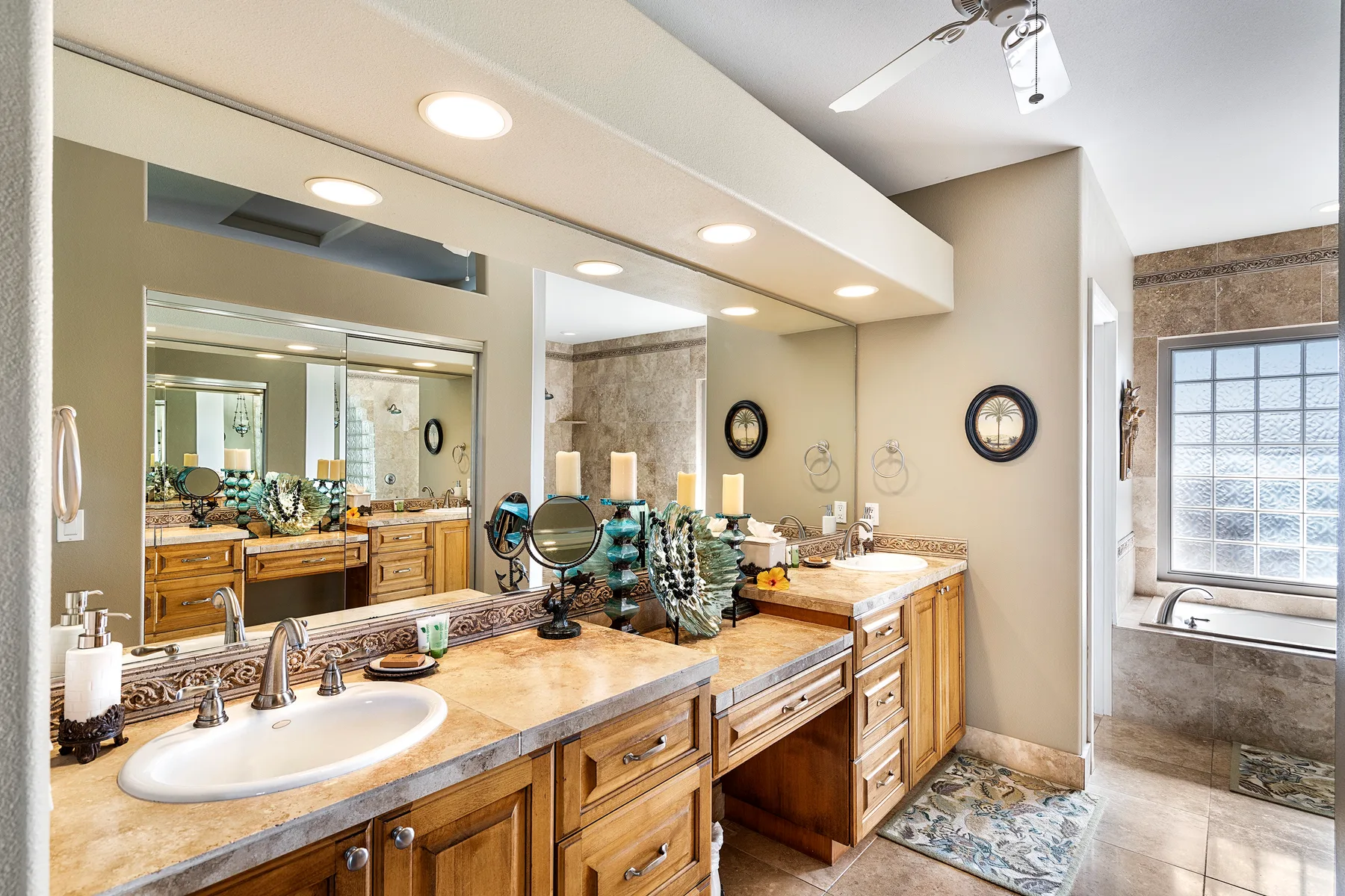 A bathroom vanity with sinks and mirrors, beside a window and bathtub.