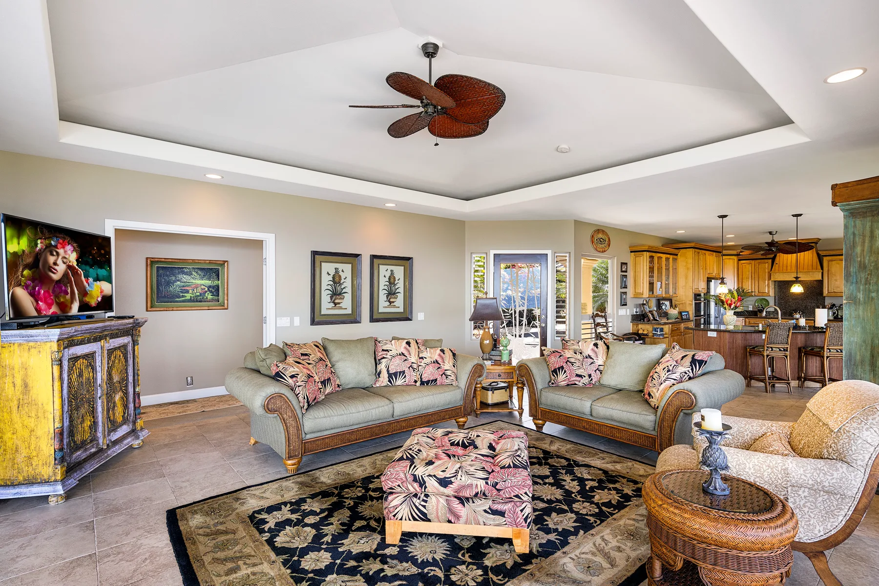A living room with patterned seating and an open kitchen in the background.