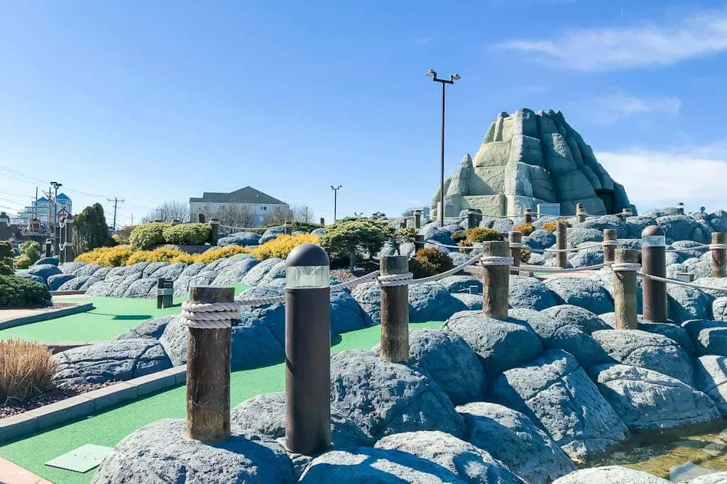 A landscaped outdoor recreation area features rocky formations and a green path.