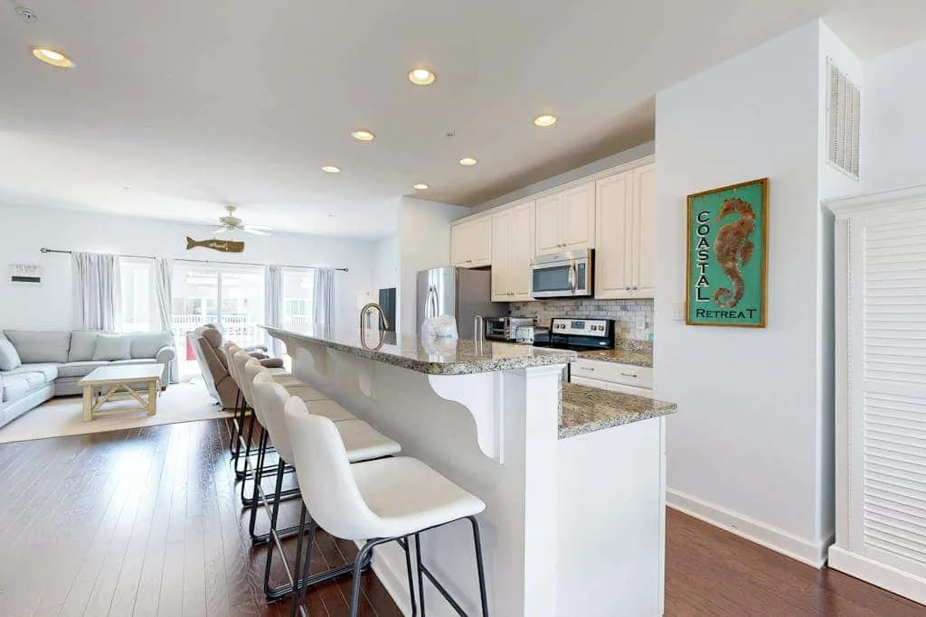 An open kitchen and living area with a long counter and bar seating.