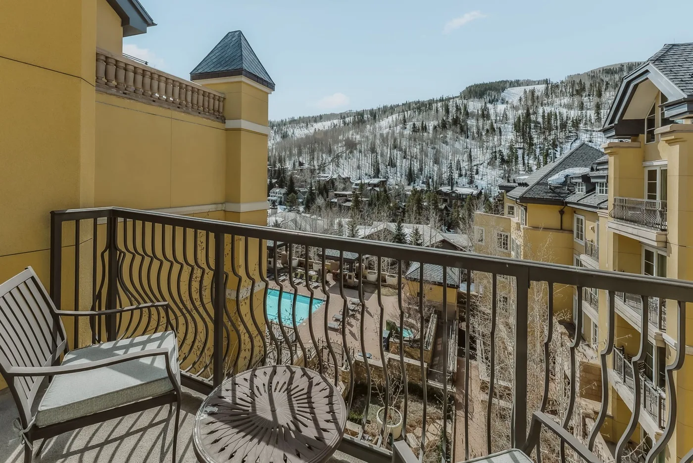 A balcony overlooks nearby buildings and a snow-dusted hillside.