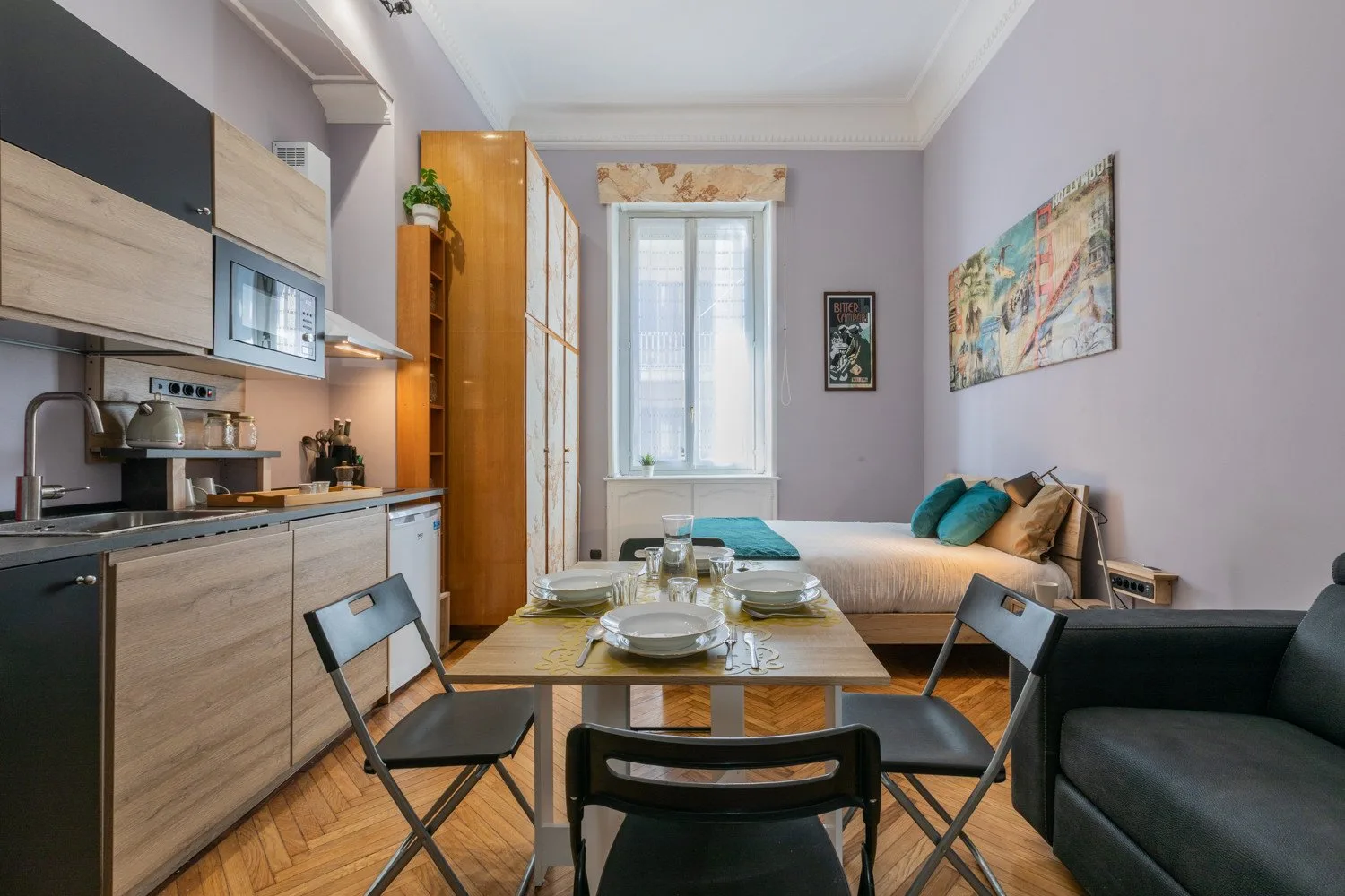 Una pequeña zona de estar y comedor incluye una cocina, una mesa y una cama.