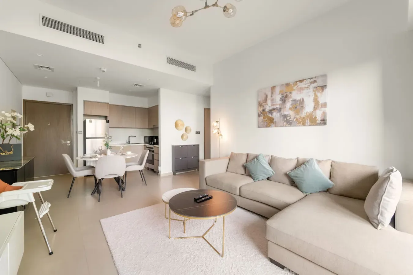 A bright open-plan living and dining area with a sectional sofa and dining table.