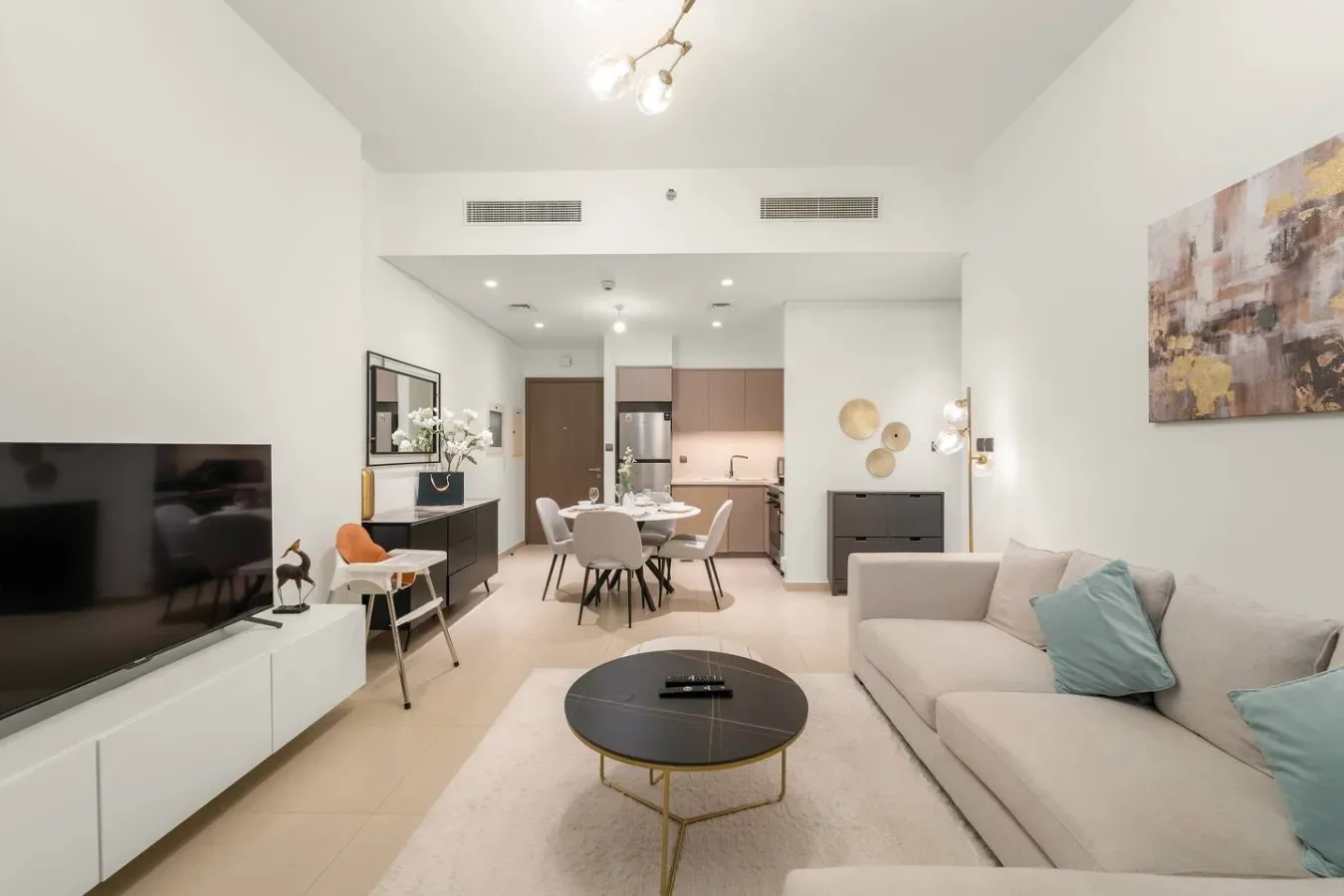 Una luminosa sala de estar y comedor diáfanos con sofá y televisor.