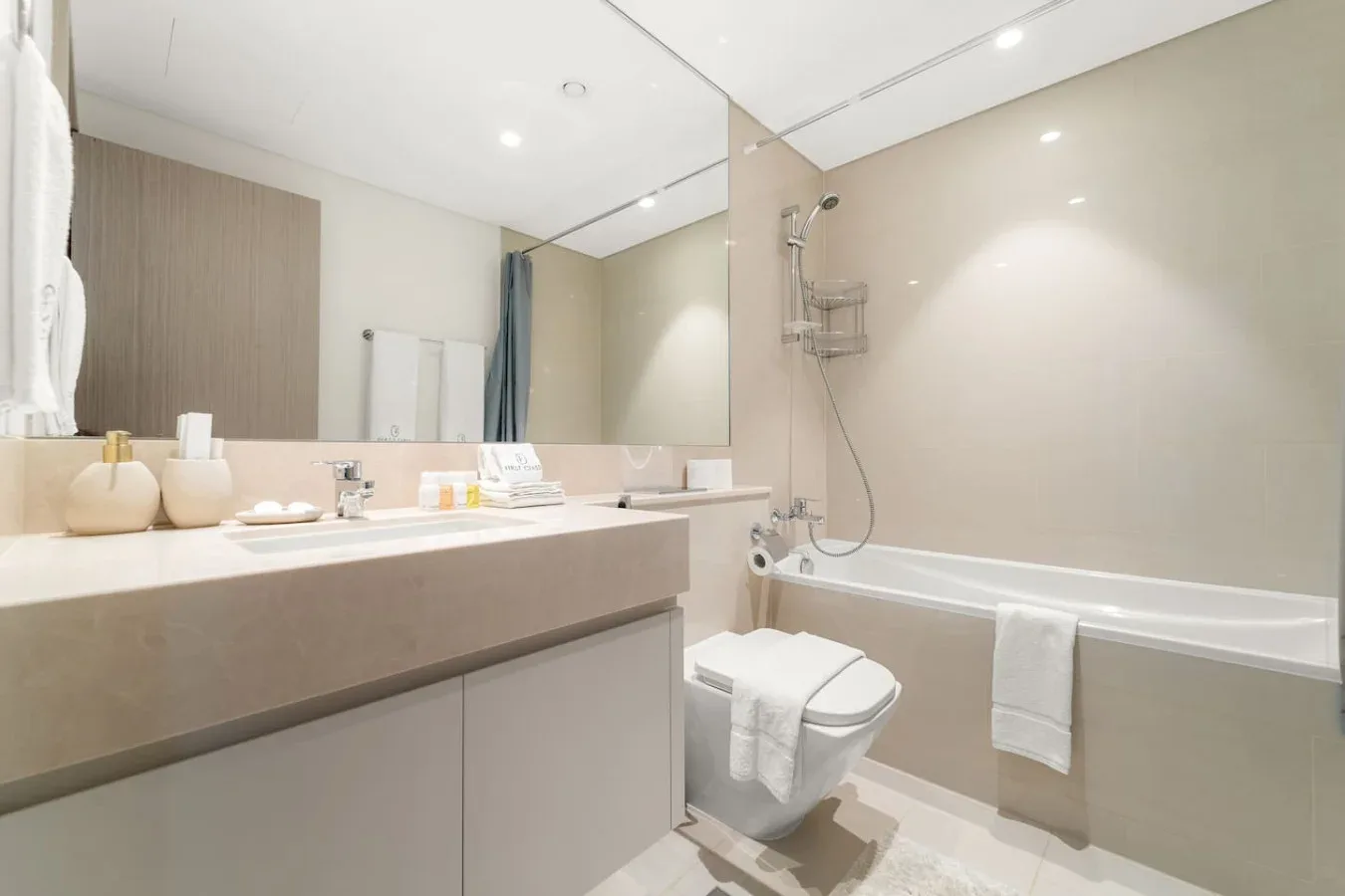 Un baño luminoso con lavabo, inodoro y bañera.