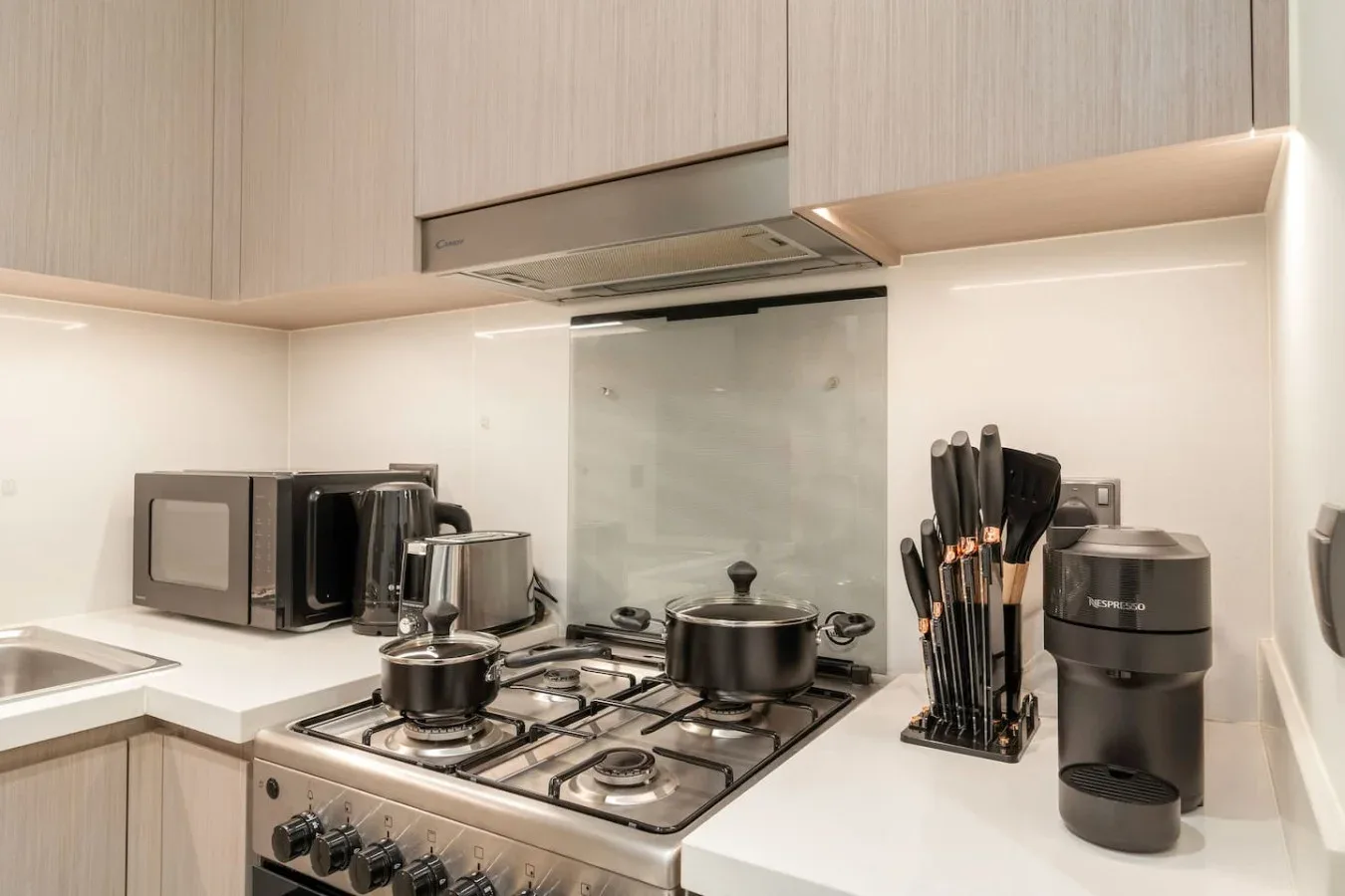 Una cocina moderna con una estufa de gas y electrodomésticos sobre la encimera.