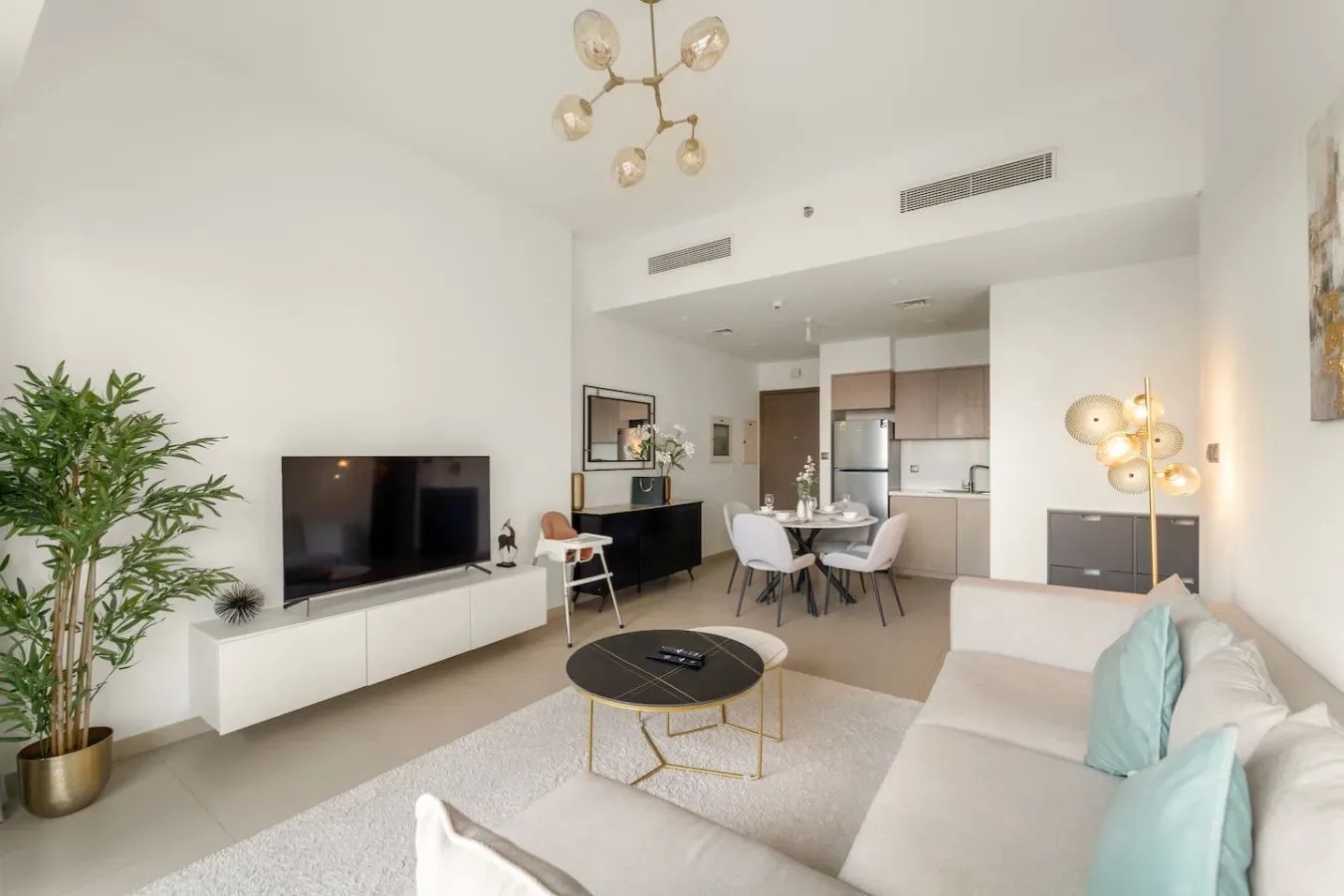 Una luminosa sala de estar de planta abierta, con comedor y cocina al fondo.