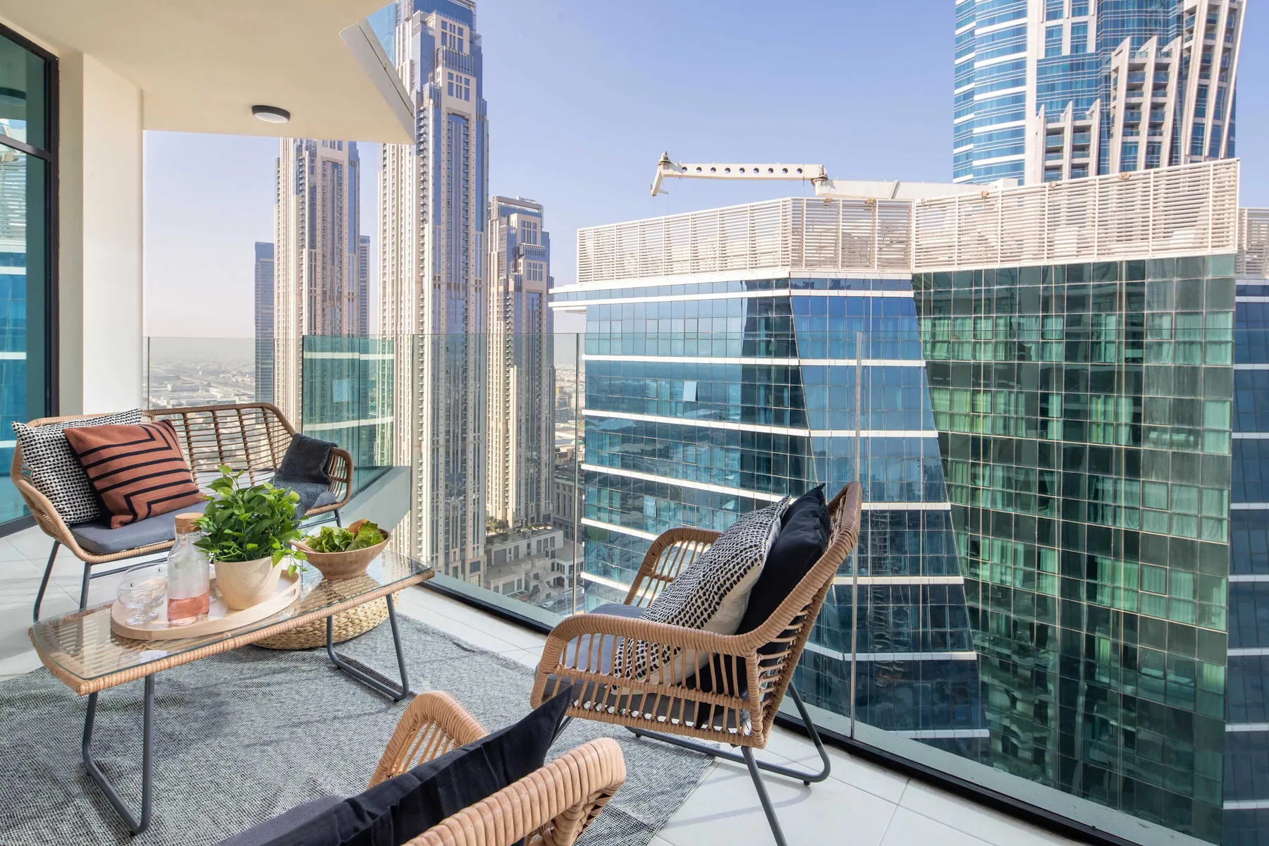 A balcony seating area overlooks modern high-rise buildings.