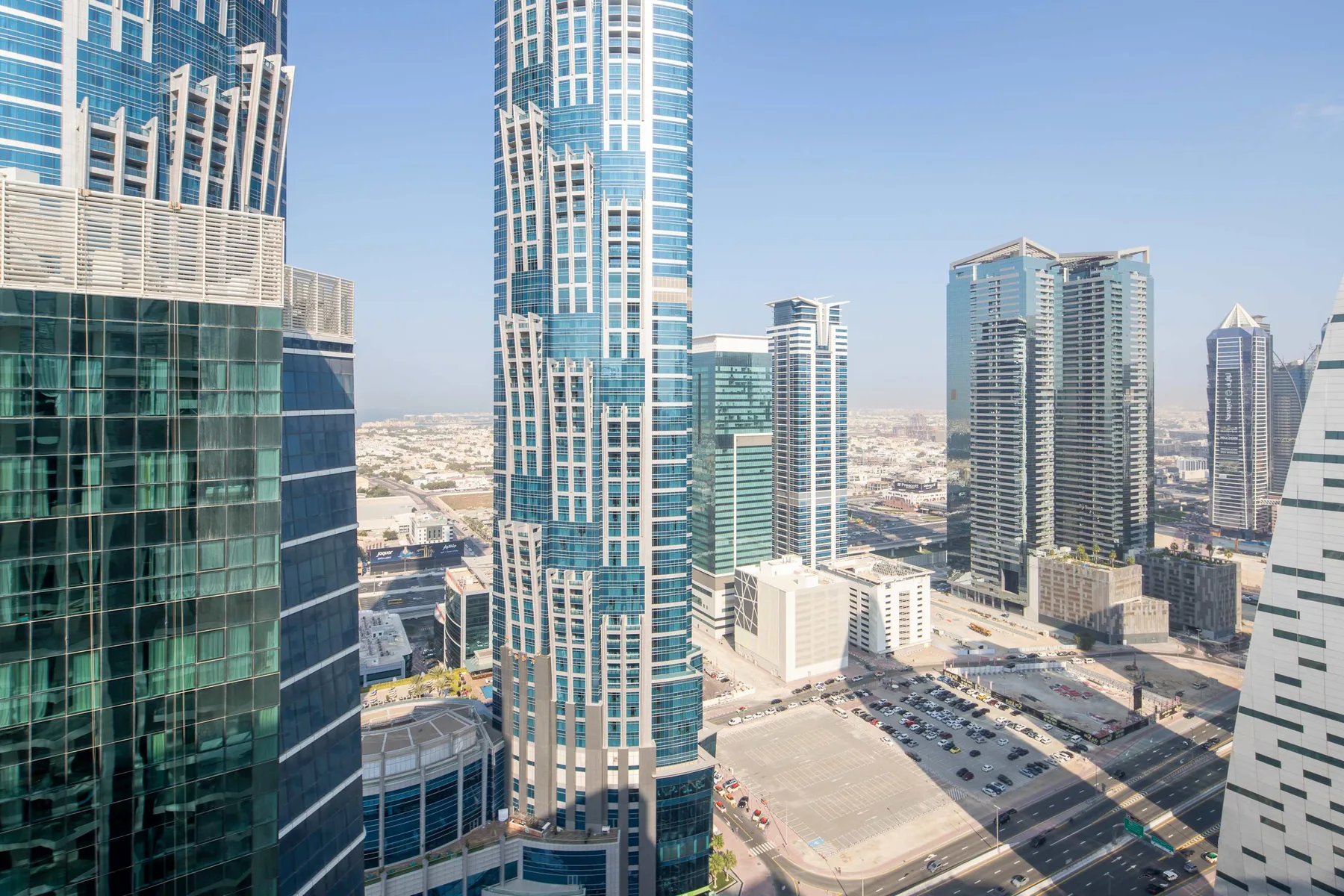 A city skyline of modern high-rise buildings under a clear sky.