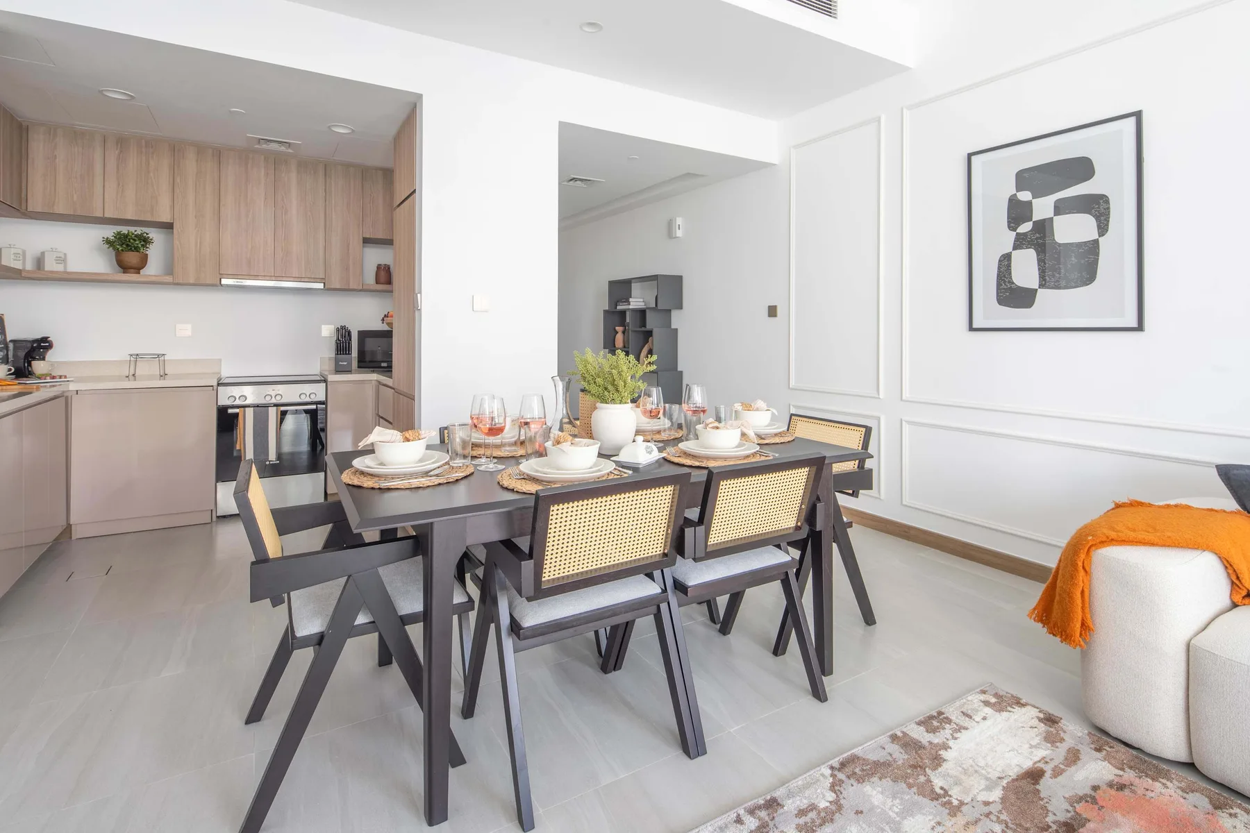 A dining area with a set table beside an open kitchen.