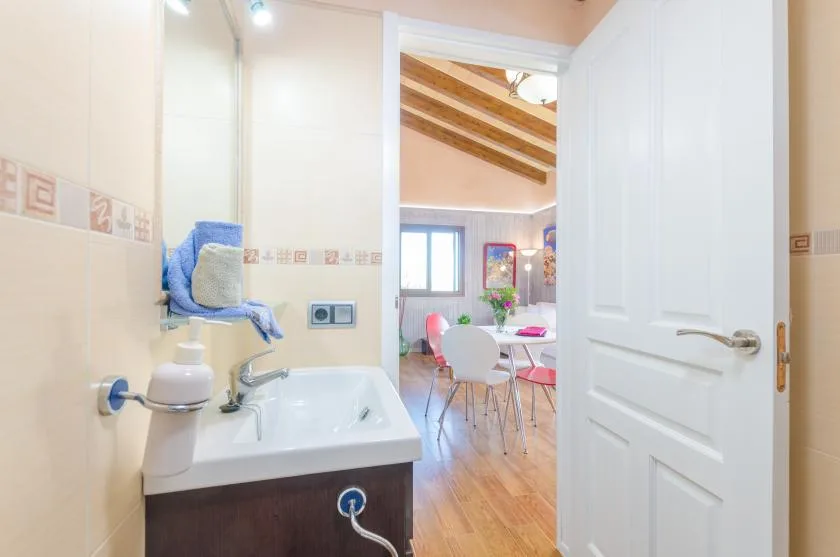 Un lavabo y tocador del baño dan a un comedor luminoso.