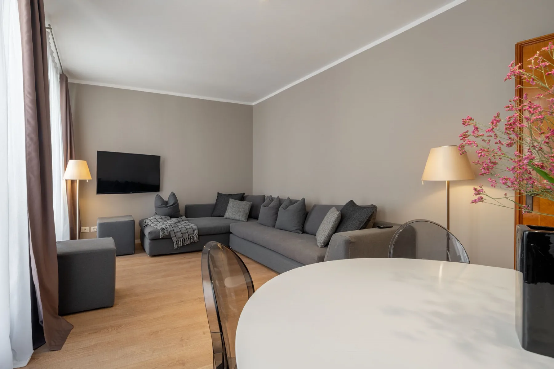 A living room with a sectional sofa and a round dining table.
