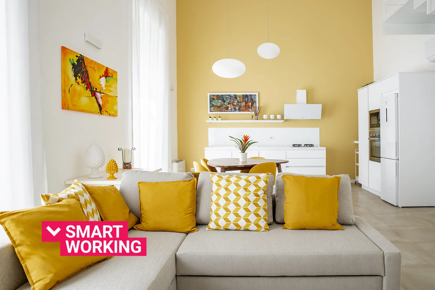 A bright living room with a gray sectional sofa and yellow accent pillows.