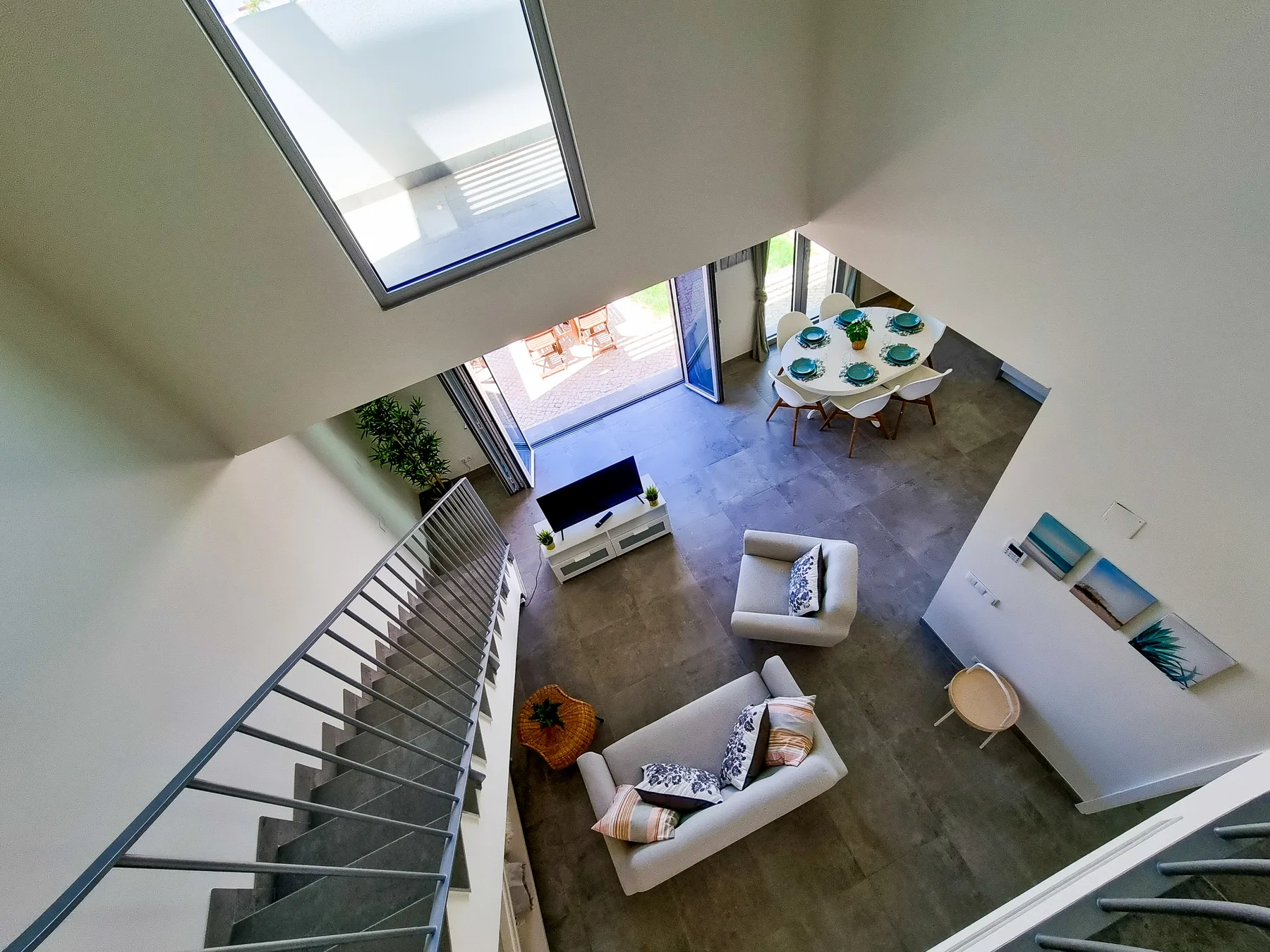 Sala de estar tipo loft con mesa de comedor y escalera.