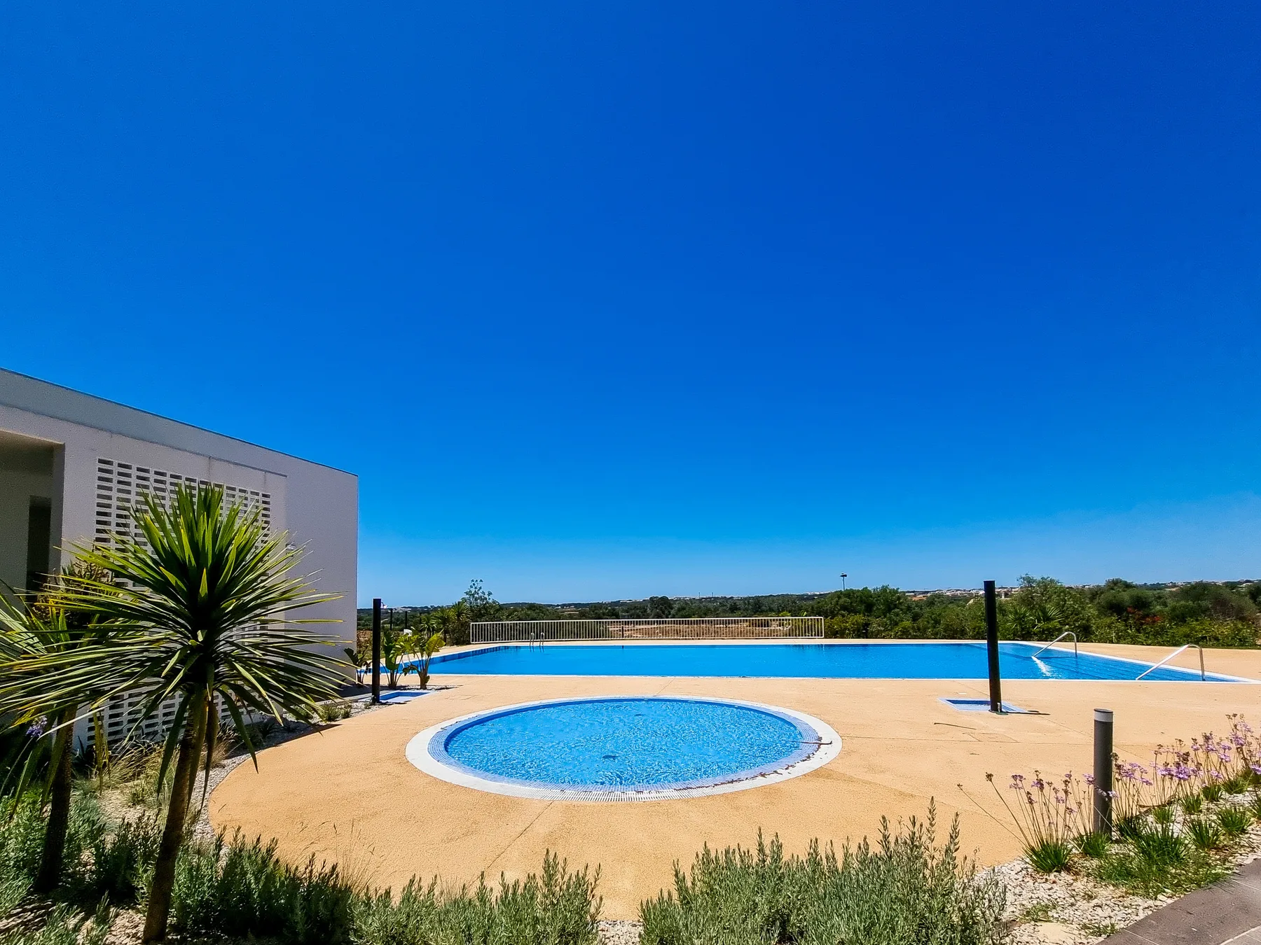 Una zona de piscina al aire libre con una piscina redonda y una amplia terraza.